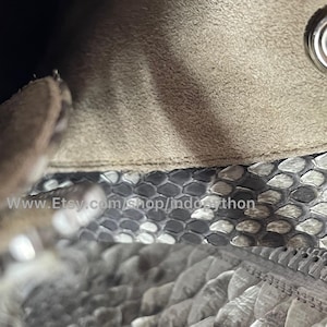May include: Close-up of a beige suede bag with a silver metal zipper and a silver metal snap closure. The bag is lined with a gray and white snakeskin pattern. The text "www.Etsy.com/shop/indopython" is visible on the lining.