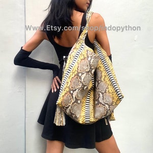 May include: A large yellow and brown snakeskin tote bag with a fringe detail. The bag is worn by a person wearing a black dress and black gloves. The text "www.Etsy.com/shop/indopython" is visible in the image.
