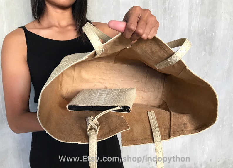 May include: A white leather tote bag with a zippered pouch inside. The bag has a brown suede lining and a top handle. The bag is open and the lining is visible. The text "www.Etsy.com/shop/indopython" is visible at the bottom of the image.