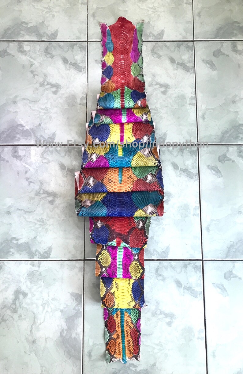 May include: A stack of colorful python skins, each with a unique pattern. The skins are arranged vertically, with the top skin being red and the bottom skin being orange. The skins are all different sizes and shapes, but they are all cut to the same length. The skins are all very vibrant and colorful, and they would be perfect for a variety of crafting projects.