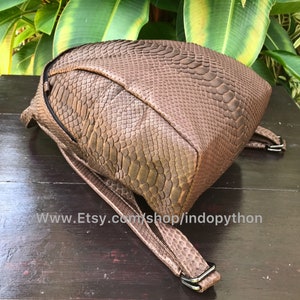 May include: A brown backpack with a snakeskin pattern. The bag has adjustable straps and a zipper closure. The Etsy shop URL is visible at the bottom of the image.