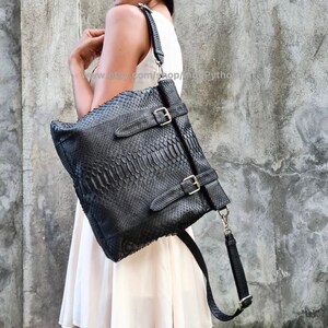 Peut inclure: Un sac &agrave; main en cuir noir avec un motif en peau de serpent et des boucles argent&eacute;es. Le sac a une longue bandouli&egrave;re r&eacute;glable.