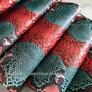 May include: Close-up of several pieces of red and green snakeskin leather. The leather has a textured, scaly pattern.