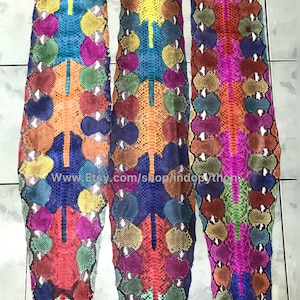 May include: Three colorful python skins with a variety of colors, including red, blue, green, yellow, and orange. The skins are arranged vertically and have a textured pattern. The text "www.Etsy.com/shop/indopython" is visible at the bottom of the image.