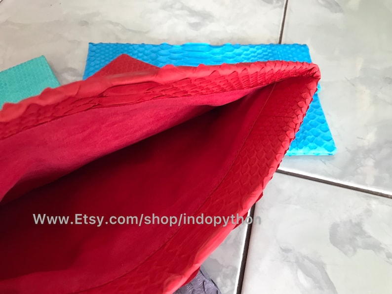 Peut inclure: Un sac &agrave; main rouge en cuir avec un ext&eacute;rieur textur&eacute;, ouvert pour r&eacute;v&eacute;ler un int&eacute;rieur rouge. Un morceau de cuir bleu est visible en arri&egrave;re-plan. L'URL de la boutique Etsy est visible en bas de l'image.