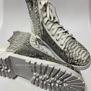 May include: White leather boots with a snake skin pattern and white laces. The boots have a chunky white sole with a tread pattern. The text "www.Etsy.com/shop/indopython" is visible on the sole.