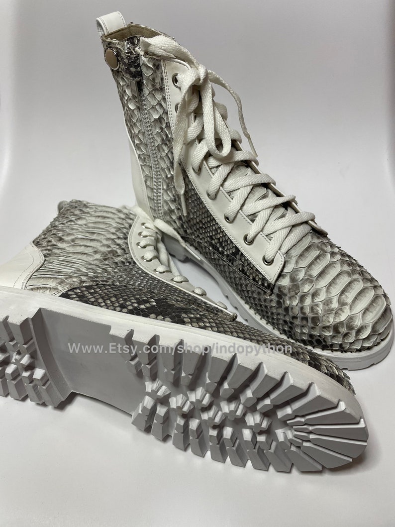 May include: White leather boots with a snake skin pattern and white laces. The boots have a chunky white sole with a tread pattern. The text "www.Etsy.com/shop/indopython" is visible on the sole.
