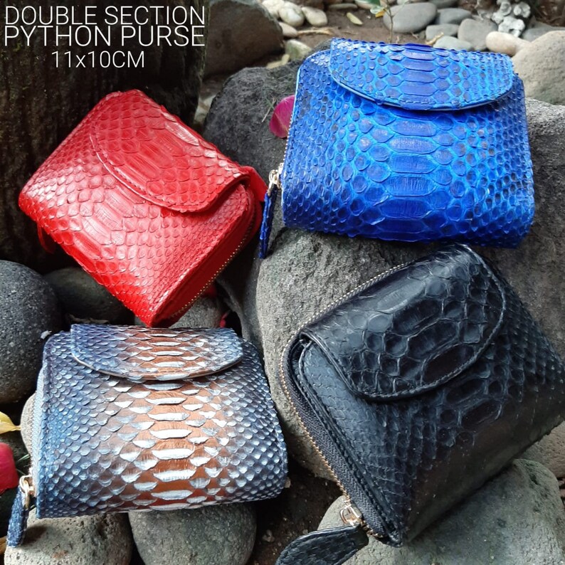 K&ouml;nnte beinhalten: Vier verschiedene Python-Leder-Geldb&ouml;rsen mit Rei&szlig;verschl&uuml;ssen. Die Geldb&ouml;rsen sind rot, blau, schwarz und in einem hellblauen und braunen Muster. Der Text "DOUBLE SECTION PYTHON PURSE 11x10CM" ist im Bild sichtbar.