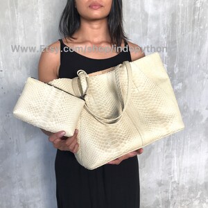May include: Two beige python leather handbags. The larger bag has two top handles and a zipper closure. The smaller bag is a clutch with a zipper closure.  www.Etsy.com/shop/lindopython