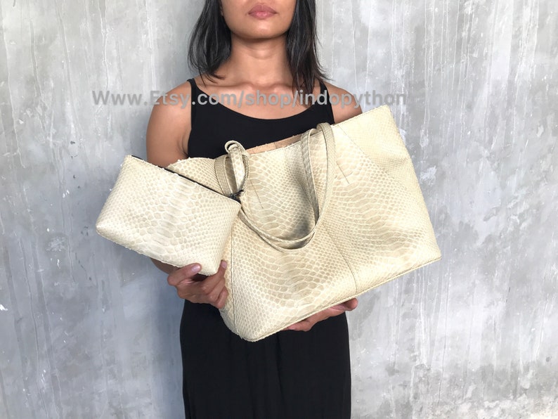 May include: Two beige python leather handbags. The larger bag has two top handles and a zipper closure. The smaller bag is a clutch with a zipper closure.  www.Etsy.com/shop/lindopython