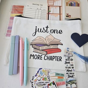 May include: A selection of reading accessories, including a white canvas pencil case with the text "just one more chapter" and a stack of books graphic. Also included are pens, highlighters, stickers, a bookmark, and a reading log.