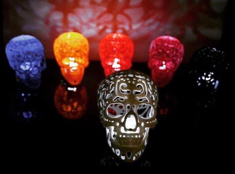 Pu&ograve; includere: Sette teschi di zucchero decorativi in ​​vari colori, tra cui blu, arancione, rosso e nero. I teschi sono realizzati con un materiale traslucido e presentano disegni intricati.