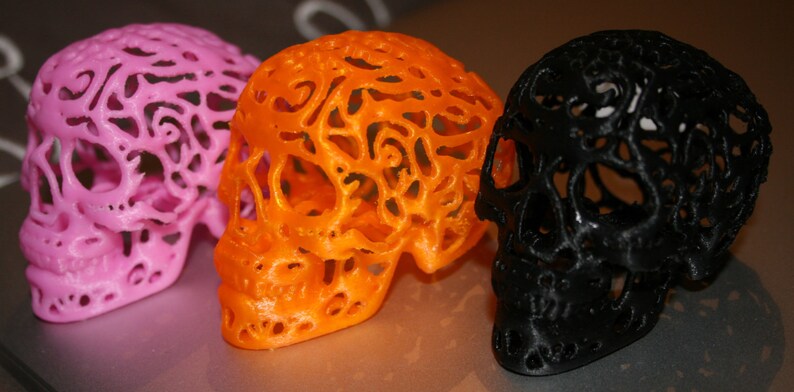Pu&ograve; includere: Tre sculture di teschio decorative, una rosa, una arancione e una nera. Ogni teschio &egrave; realizzato in un materiale traslucido con un design dettagliato e intricato.