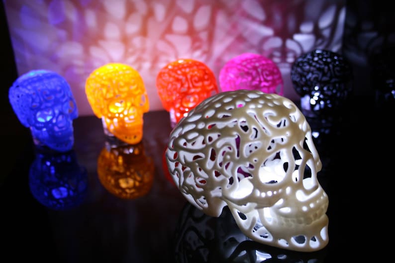 Pu&ograve; includere: Un set di sei lampade decorative a forma di teschio in vari colori, tra cui blu, arancione, rosso, rosa, nero e bianco. Le lampade sono realizzate in un materiale traslucido e hanno un design delicato e intricato.
