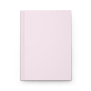 Puede incluir: Un cuaderno liso de color rosa claro con una portada en blanco.