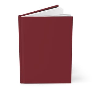 Puede incluir: Un diario de tapa dura con una cubierta de color burdeos oscuro. El diario está ligeramente abierto, revelando las páginas blancas en el interior. El lomo es visible y el libro está sobre un fondo blanco.