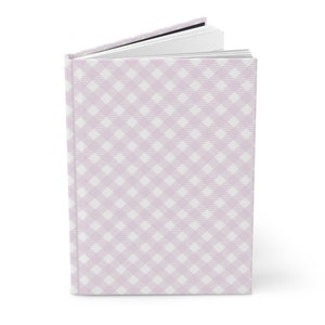 Könnte beinhalten: Ein Hardcover-Notizbuch mit rosa und weißem Gingham-Muster.