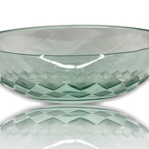May include: A large, clear glass bowl with a geometric pattern etched into the bottom. The bowl is oval shaped and has a slight green tint.