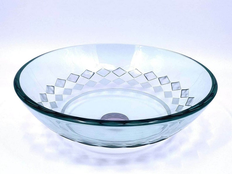 May include: A clear glass bathroom sink with a diamond pattern etched into the bottom. The sink is round and has a smooth, polished finish.
