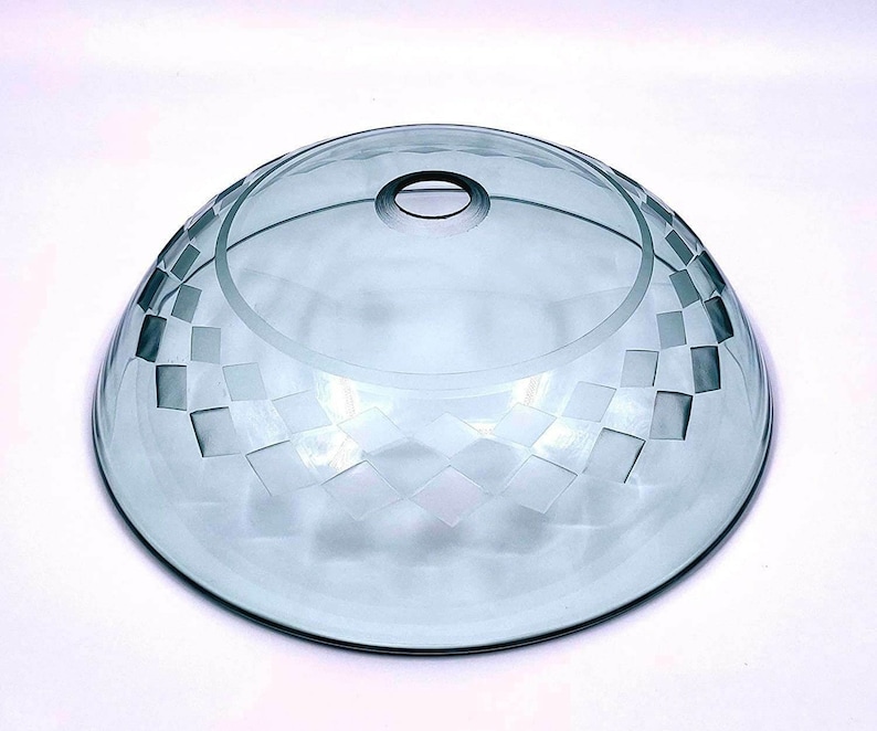 May include: A clear glass bowl with a frosted, geometric pattern. The bowl has a rounded shape and a slightly raised rim.