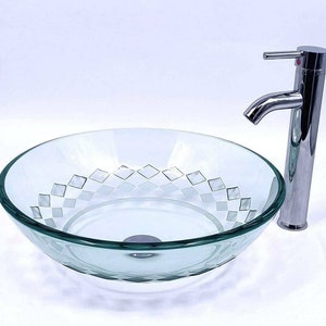 May include: A clear glass vessel sink with a diamond pattern etched into the bottom. The sink is paired with a chrome faucet.