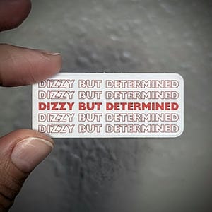 May include: White sticker with the phrase "Dizzy But Determined" repeated five times in red text.