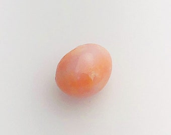 May include: A single, oval-shaped, peach-colored pearl.