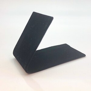 May include: A black velvet ring display stand, angled to show off a ring or other small item.