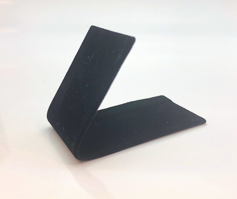 May include: A black velvet ring display stand, angled to show off a ring or other small item.