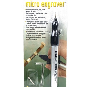 Könnte beinhalten: Ein silbernes und schwarzes Mikro-Gravierwerkzeug mit einem stiftartigen Design. Die Verpackung enthält den Text "BEADSMITH micro engraver" und "the BEADSMITH".