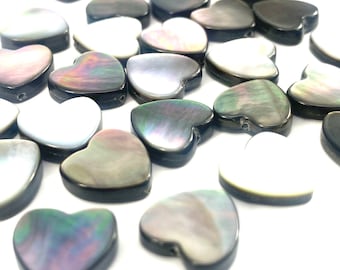 May include: A collection of heart-shaped shell beads in shades of black, white, and iridescent gray. The beads have a smooth, polished finish and are perfect for jewelry making.