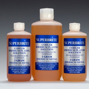 May include: Three amber glass bottles with blue labels containing rhodium plating solution. The labels state "Superbrite" and "Cohler Rhodium Plating Solution" and list the amount of rhodium metal in each bottle: 2 grams, 2 grams, and 1 gram. The labels also include the company name and contact information.