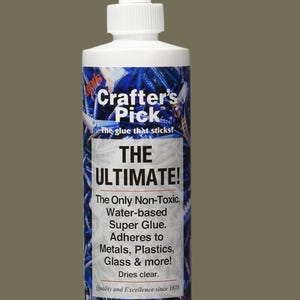 Puede incluir: Una botella blanca de pegamento súper fuerte no tóxico a base de agua Crafter's Pick The Ultimate. La botella está etiquetada con un fondo azul y plateado con tornillos y pernos. La etiqueta indica que el pegamento se adhiere a metales, plásticos, vidrio y más. También indica que el pegamento se seca transparente y que contiene 236 ml.