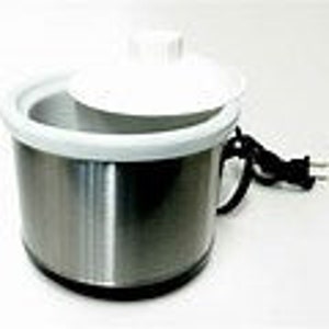 Op de afbeelding: Een kleine, zilveren, elektrische slowcooker met een wit deksel. De slowcooker heeft een zwarte basis en een snoer.