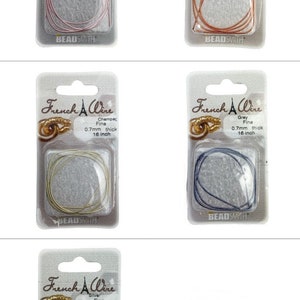 May include: Four packs of French Wire, each containing a spool of 0.7mm thick wire in a different colour: rose gold, copper, champagne, and grey. Each pack features the brand name "French Wire" and the colour of the wire.