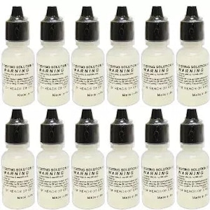 May include: Ten small clear plastic bottles with black caps. Each bottle has a label that reads "Testing Solution Warning" and "Keep out of reach of children".