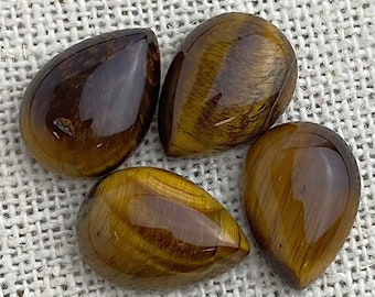 May include: Four teardrop-shaped tiger's eye stones with a golden brown color and a chatoyant effect.
