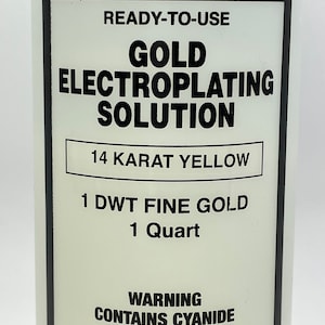 Puede incluir: Primer plano de una etiqueta de botella para solución de galvanoplastia de oro. La etiqueta es blanca con texto negro que dice "READY-TO-USE GOLD ELECTROPLATING SOLUTION 14 KARAT YELLOW". También incluye una advertencia sobre el cianuro.