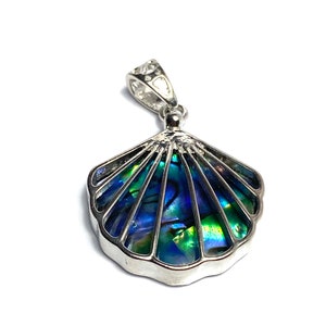 Könnte beinhalten: Ein silberner Anhänger mit einer blauen und grünen Abalone-Muschel mit einem detaillierten, komplizierten Design.