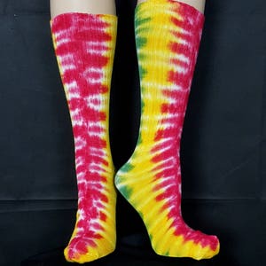 May include: A pair of colorful tie-dye socks in red, yellow, and green. The socks are made of a soft, comfortable material and are perfect for adding a pop of color to any outfit.