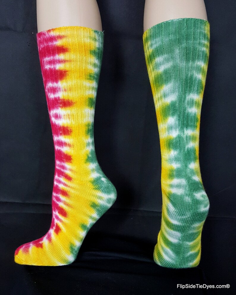May include: A pair of tie-dye socks with a red, yellow, and green color scheme. The socks are made of cotton and have a ribbed texture.