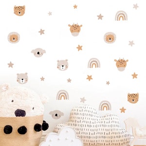 May include: A set of beige and brown animal and rainbow wall decals. The decals feature a lion, giraffe, koala, bear, leopard, and rainbows. The decals are perfect for a nursery or child's room.