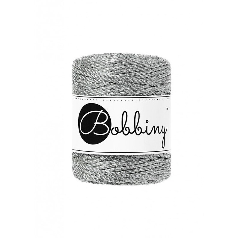 May include: A spool of silver metallic twine with a white label that says "Bobbiny" in black cursive lettering.