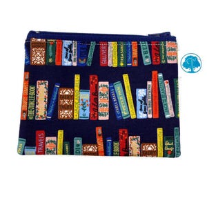 May include: A navy blue zippered pouch with a repeating pattern of colorful books on a bookshelf. The pouch is made of fabric and has a zipper closure.