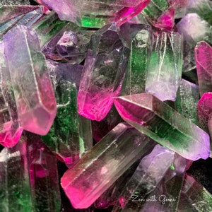 May include: A close-up of a pile of iridescent, faceted, crystal points in shades of pink, green, and purple. The crystals are arranged in a random pattern, with some points pointing upwards and others pointing downwards. The crystals are all about the same size, and they are all very shiny. The text "Zen with Gems" is visible in the lower right corner of the image.