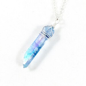 May include: A silver chain necklace with a blue iridescent crystal pendant wrapped in silver wire.