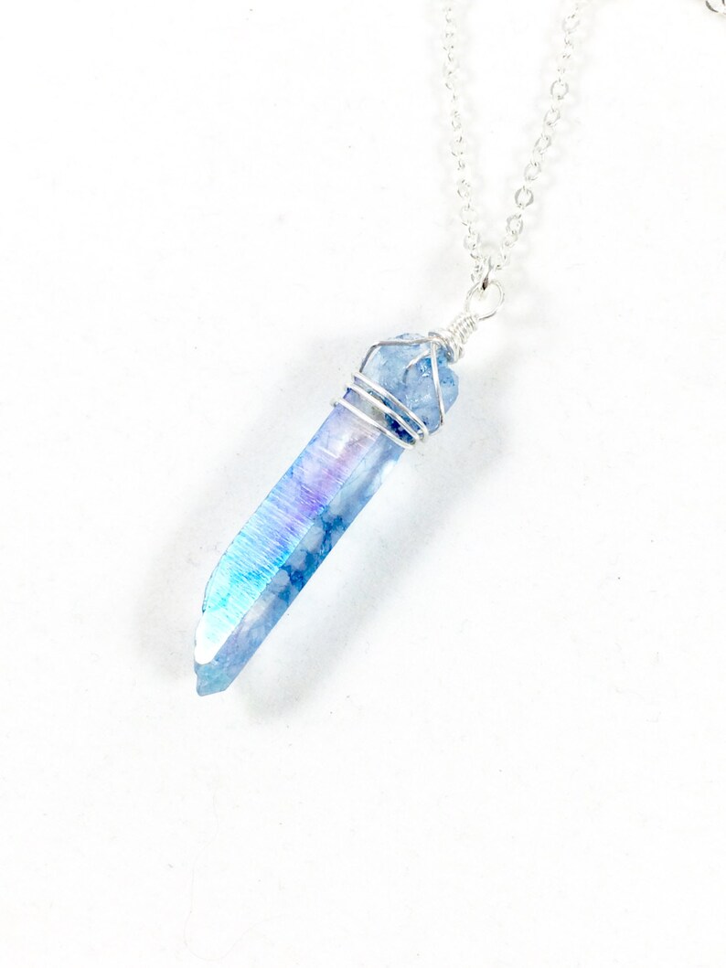 May include: A silver chain necklace with a blue iridescent crystal pendant wrapped in silver wire.