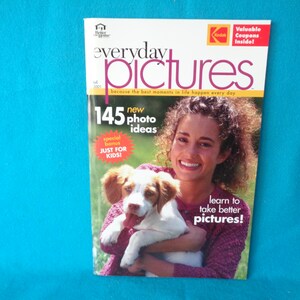 May include: A magazine cover featuring a young woman holding a brown and white puppy. The magazine is titled "everyday pictures" and has the text "145 new photo ideas" and "learn to take better pictures!" on the cover.