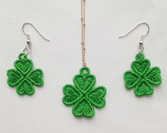 May include: A set of green four-leaf clover earrings and a necklace. The jewelry is made of green fabric and has a delicate, intricate design.
