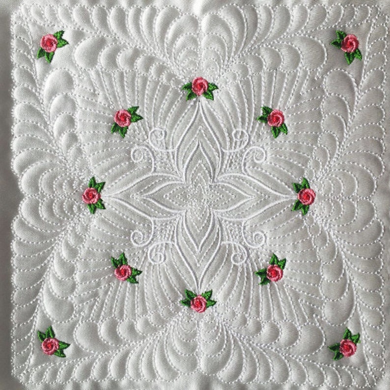 May include: White quilted fabric with a floral design. The fabric is quilted in a pattern of small circles and has a central design of a large flower with smaller flowers around it. The flowers are pink with green leaves.